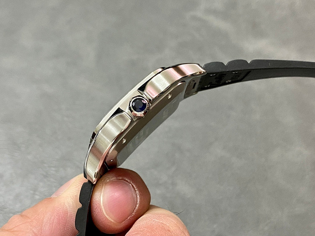 Cartier wristwatch side view with blue gemstone crown and silver-toned case