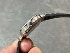 Cartier wristwatch side view with blue gemstone crown and silver-toned case