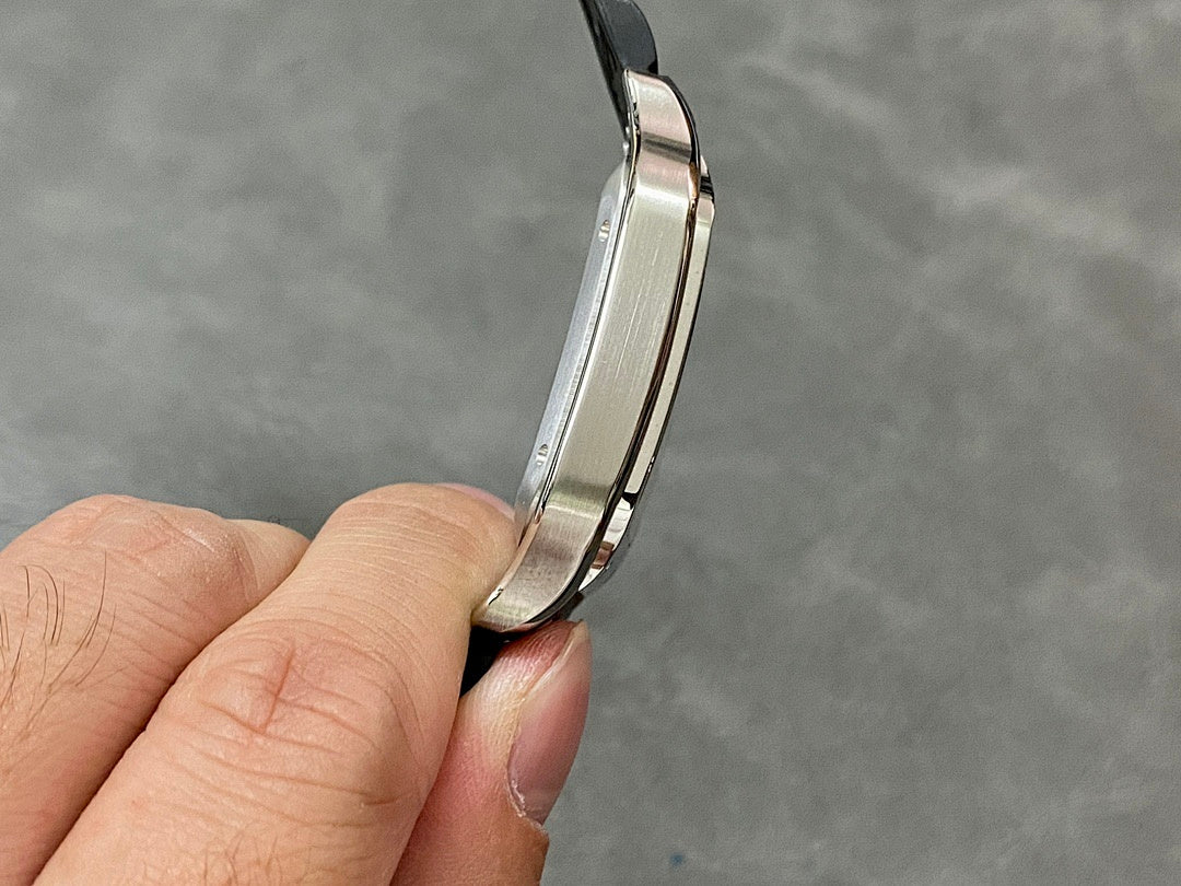 Cartier wristwatch profile view showing silver-toned case edges and black strap