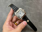 Cartier wristwatch on hand, black leather strap and silver-toned square case with Roman numerals