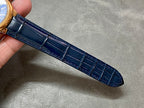 Blue leather watch strap with stitched pattern and polished gold case edge
