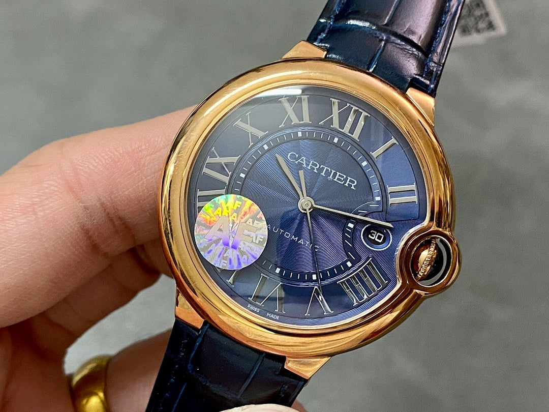 Cartier watch with gold bezel, blue dial, Roman numerals, and blue leather strap
