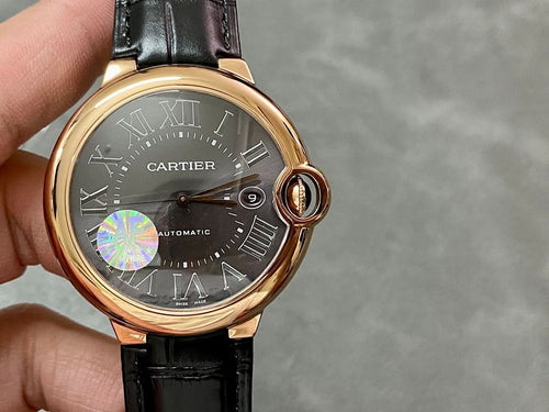 Cartier watch angled view, rose-gold case with crown, black leather strap, Roman numerals