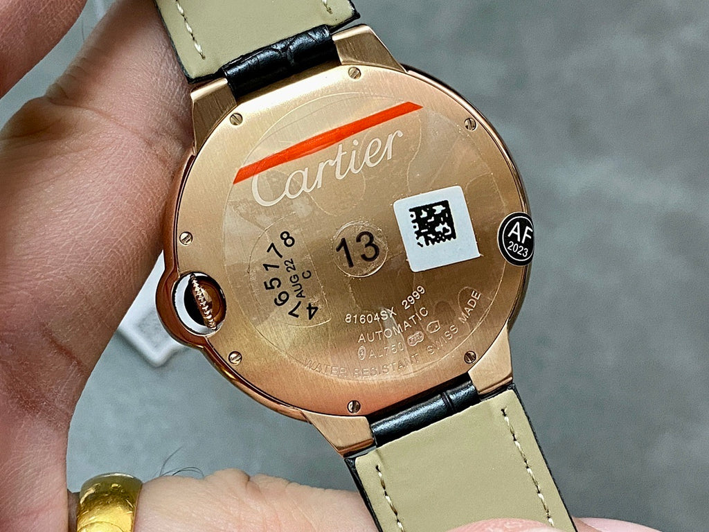 Cartier watch case back in rose gold, black strap, engraved details and logo