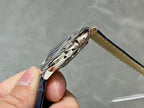 Cartier watch side profile with polished metal case and blue leather strap