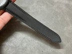 Black fabric watch strap with textured weave, laid flat