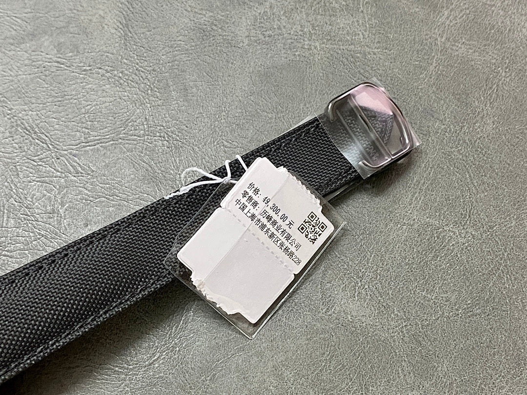 Black fabric watch strap with metal buckle and white barcode tag