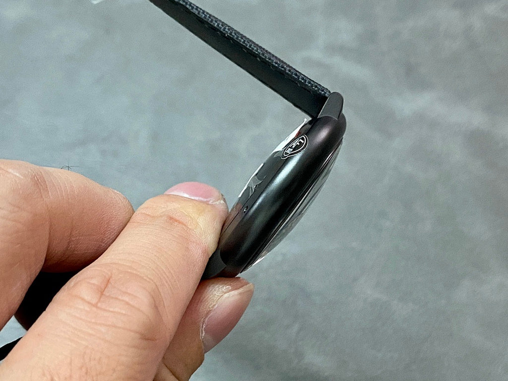 Cartier wristwatch from side angle with black case and black textured strap
