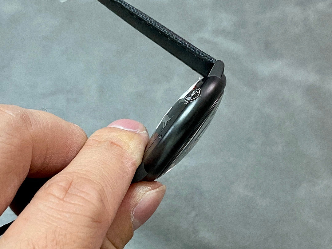 Cartier wristwatch from side angle with black case and black textured strap