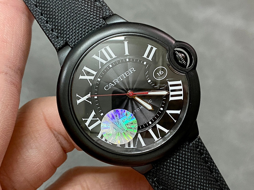 Cartier wristwatch face with black dial, Roman numerals, and date window 16 on black strap