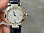 Cartier wristwatch front view with silver dial, blue leather strap, and crown details.