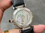 Cartier wristwatch case back with visible mechanical movement and dark blue leather strap.