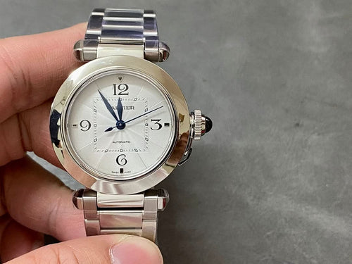 Cartier watch with silver metal bracelet and white dial, blue hands, visible crown on case
