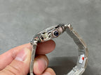 Cartier watch with silver metal bracelet and blue gemstone accent on bezel
