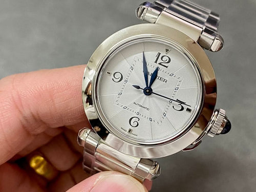 Cartier watch with silver metal bracelet, white dial, blue hands, crown and pushers