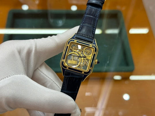 Gold-tone wristwatch with black leather strap and square skeleton dial, side view
