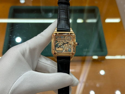 Gold-tone square wristwatch with black leather strap and decorative blue face