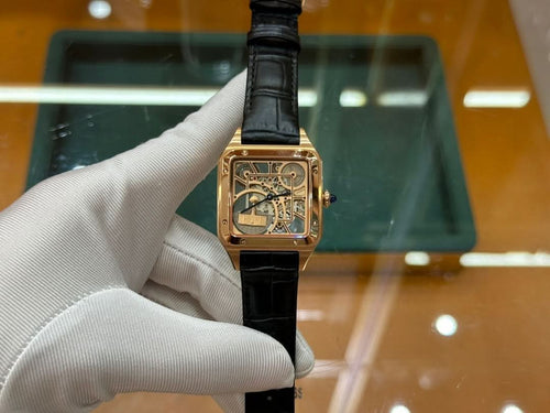 Gold-tone square wristwatch with black leather strap, face detail visible