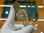 Gold-tone square wristwatch with green leather strap, angled side view