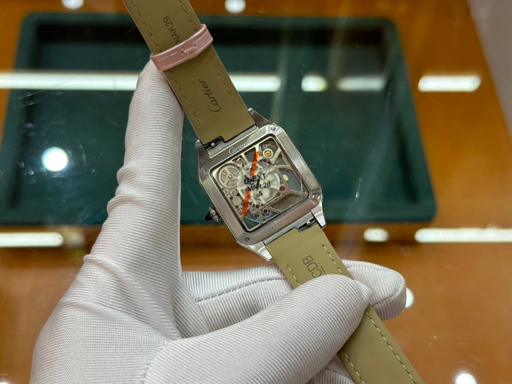 Cartier watch with leather strap and rectangular silver case, visible mechanical movement detail