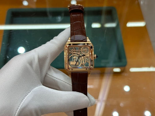Wristwatch with brown leather strap and gold-tone square case, angled front