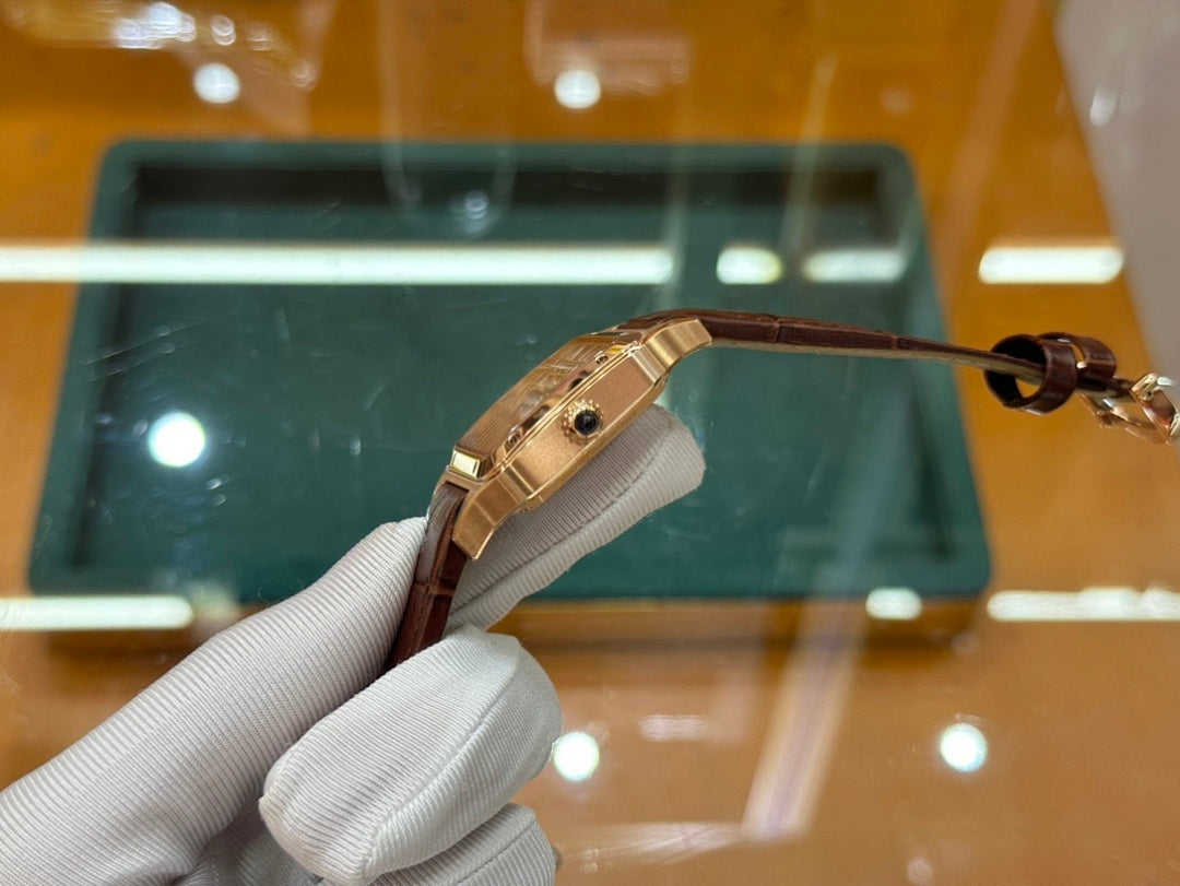 Wristwatch with brown leather strap and gold-tone clasp, side view