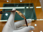 Wristwatch with brown leather strap and gold-tone case, top-side angle