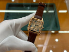 Wristwatch with brown leather strap and gold-tone square case, front view