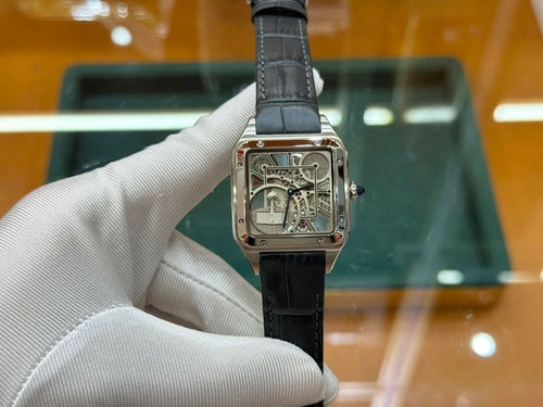 Rectangular skeleton dial wristwatch with black leather strap, held upright