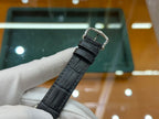 Rectangular wristwatch with black leather strap and metal clasp buckle
