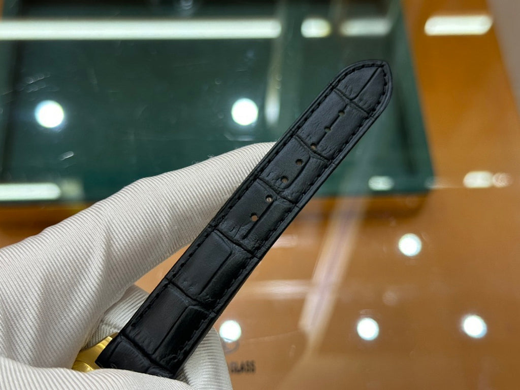 Cartier wristwatch view of black leather strap and gold-tone watch case