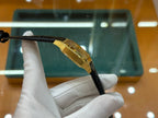 Cartier wristwatch with gold-tone case side and black leather strap detail