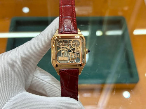 Gold-tone Cartier watch with red leather strap and square skeleton dial