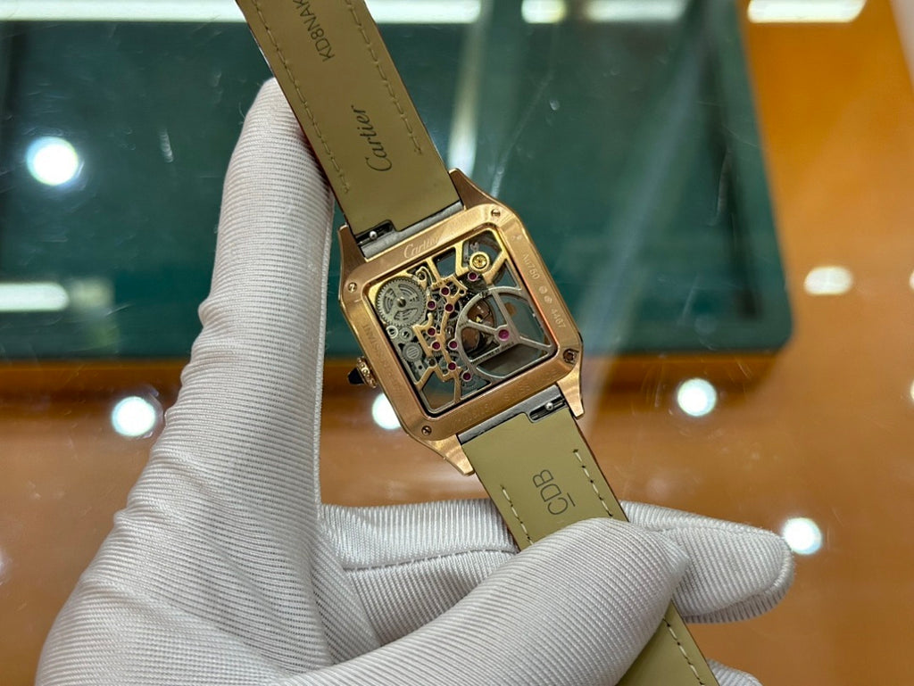 Gold-tone Cartier watch on red leather strap, angled view of case and dial
