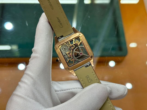 Gold-tone Cartier watch on red leather strap, angled view of case and dial