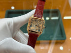 Gold-tone Cartier watch with red leather strap and square skeleton dial, front view