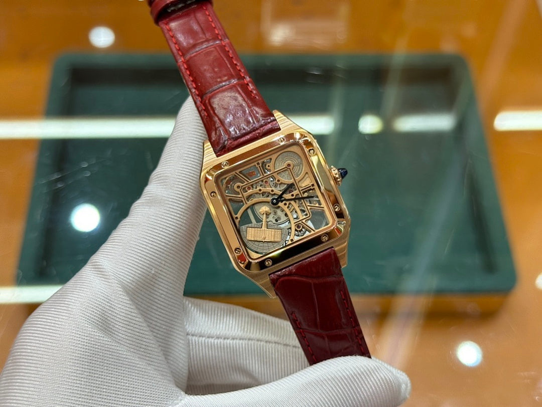 Gold-tone Cartier watch with red leather strap, angled view of square skeleton dial