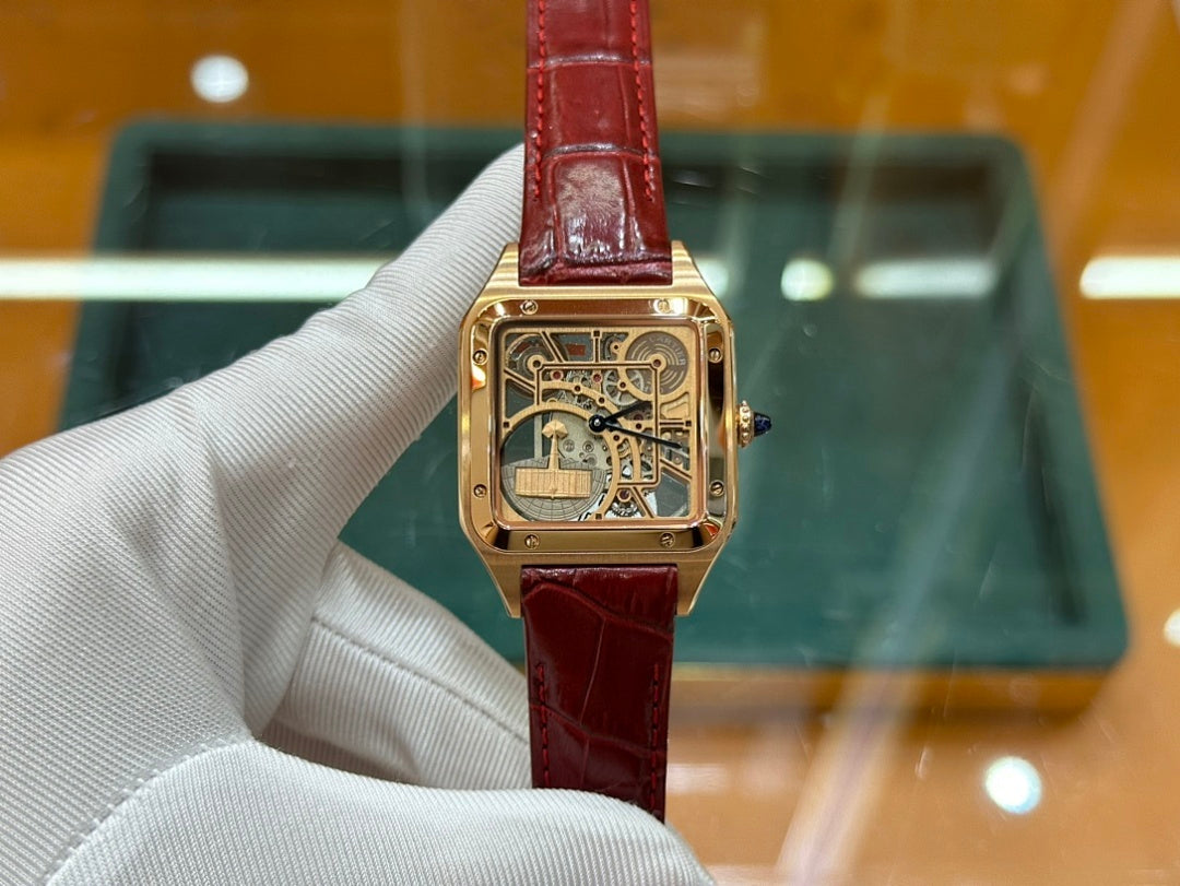 Gold-tone Cartier watch with red leather strap and square skeleton dial, centered