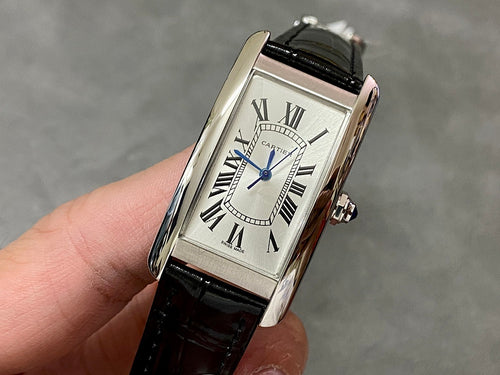 Rectangular wristwatch with silver-tone case, white dial, blue hands, black leather strap.