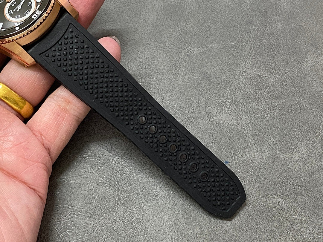 Black rubber watch strap with textured pattern and adjustment holes