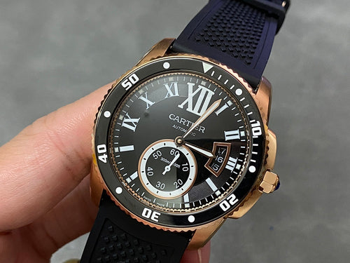Gold-tone dive watch with black dial, Roman numerals, and subdial indicators