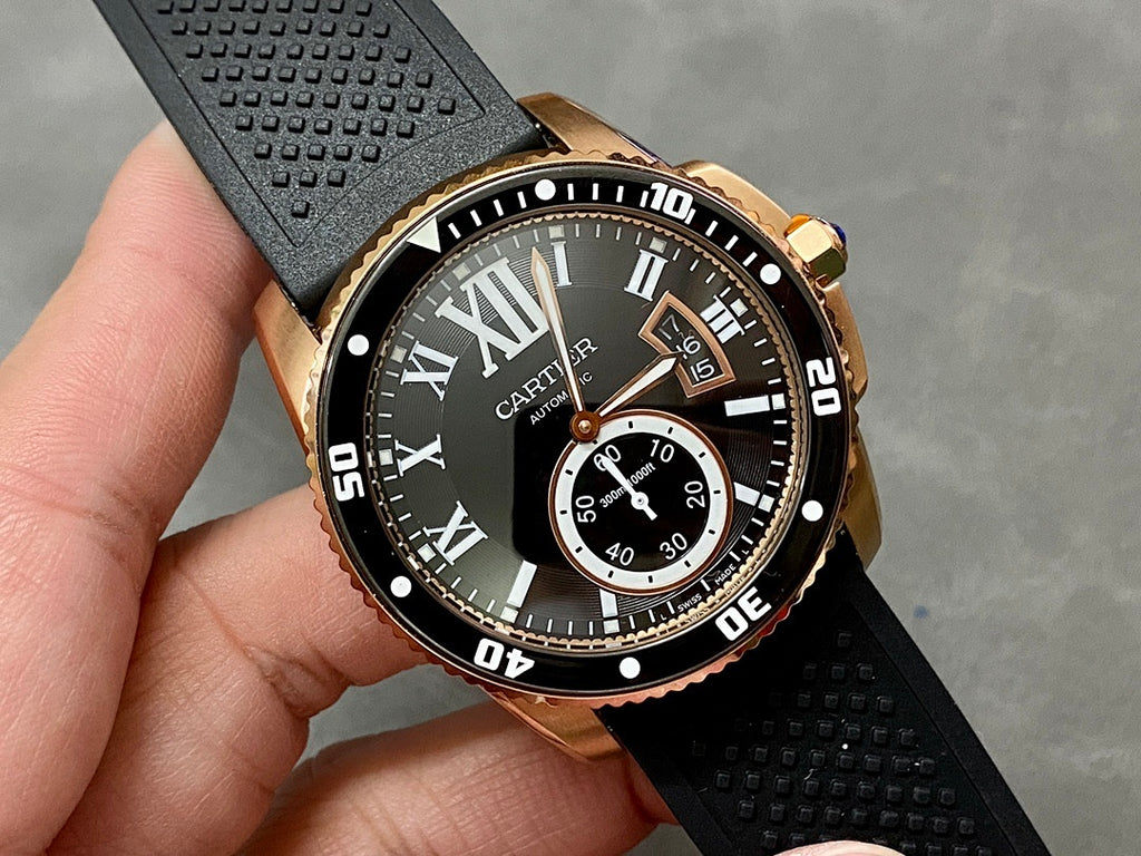 Gold-tone dive watch close-up with black dial, Roman numerals, and subdial window