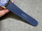 Textured blue silicone watch strap with small circular grip dots and perforations