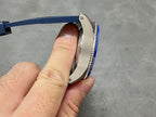 Side profile of blue dive watch with ridged bezel and stainless case edge