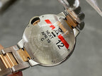 Back of a gold and silver automatic wristwatch with markings and red tag