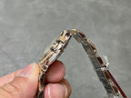 Gold and silver wristwatch case profile with crown detail