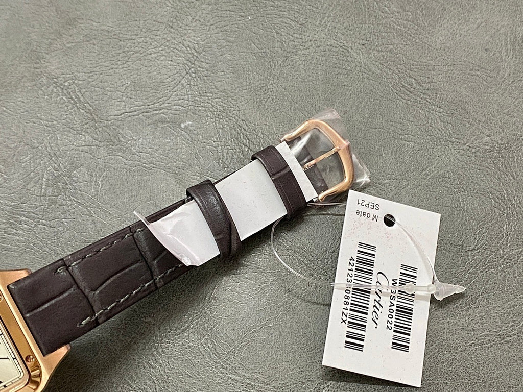 Cartier wristwatch buckle and strap: rose gold case end with black leather strap and paper tags