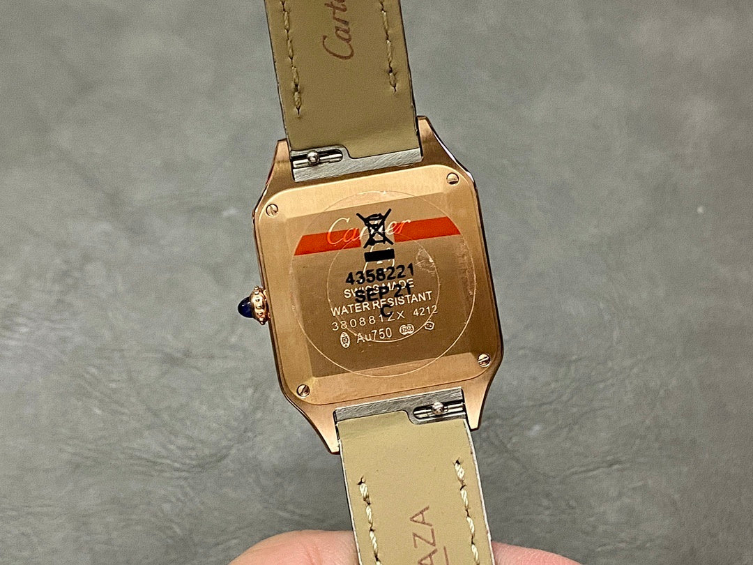 Cartier wristwatch case back: rose gold backplate with markings and red label, on black leather strap