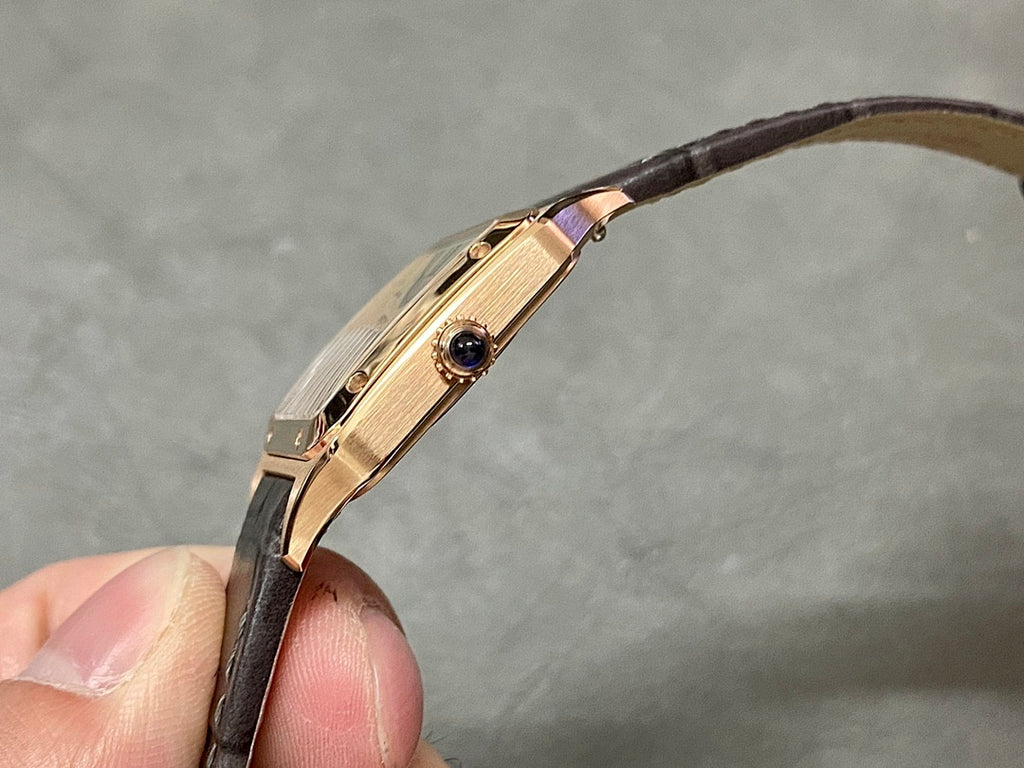 Cartier wristwatch side profile: rose gold case with crown detail, black leather strap