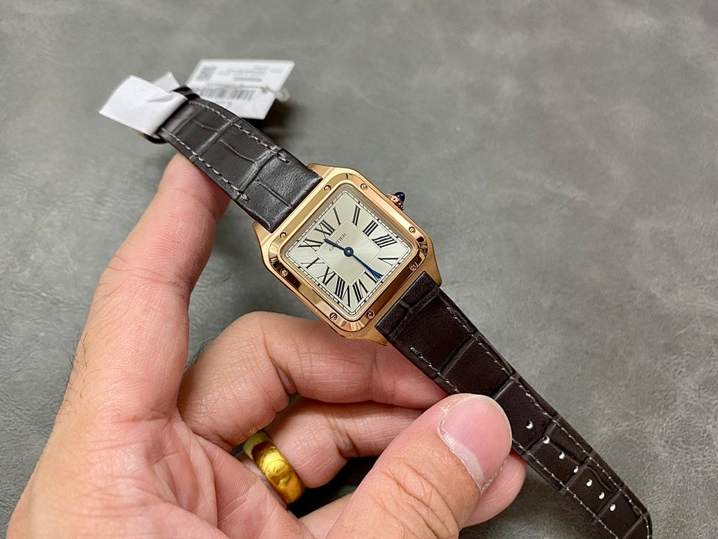 Cartier wristwatch angled on hand: rose gold square case, white dial with Roman numerals, black leather strap